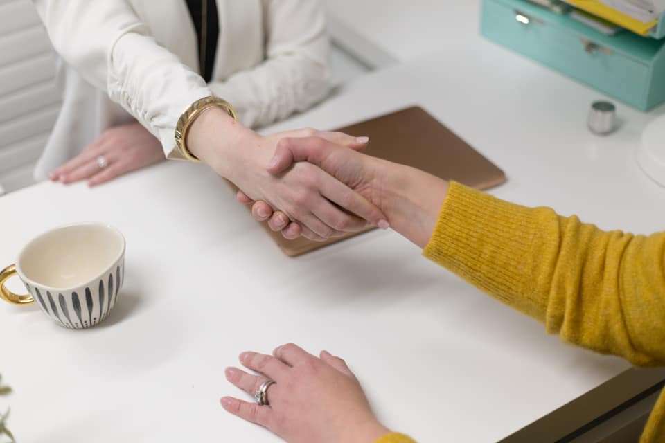 legal-handshake Twee mensen geven elkaar een hand aan tafel